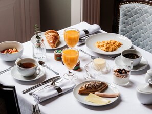 A breakfast setting with croissants, fruit, scrambled eggs, orange juice, coffee, and a variety of spreads on a table. - Dear Lisbon -Valmor Palace (Lisbon)