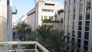 A balcony with white railings and red roses, overlooking a cityscape with buildings and palm trees. - Da Mary Guest House (Palermo)