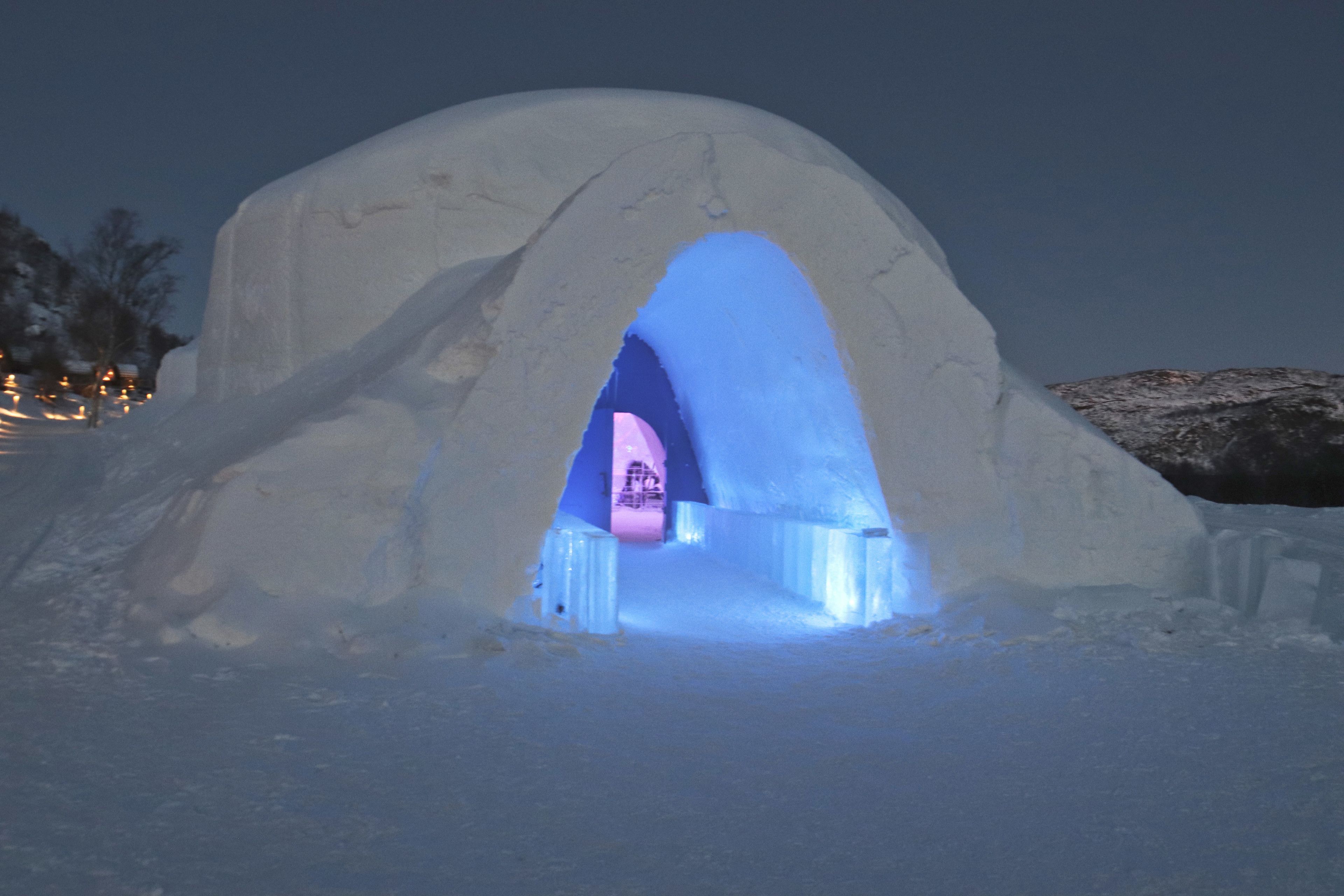 Una iglú con una entrada iluminada en azul.