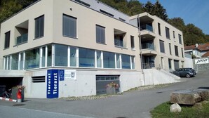 Un edifici modern amb teulada plana, grans finestres i un rètol que diu 'Tierarzt Tierarzt'.