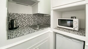 A compact kitchen with a sink, a microwave, and a dishwasher. - Locanda Parlamento (Rome)