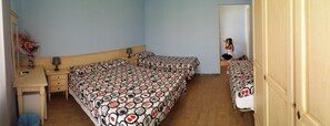 Un dormitorio con dos camas, un escritorio y un espejo.