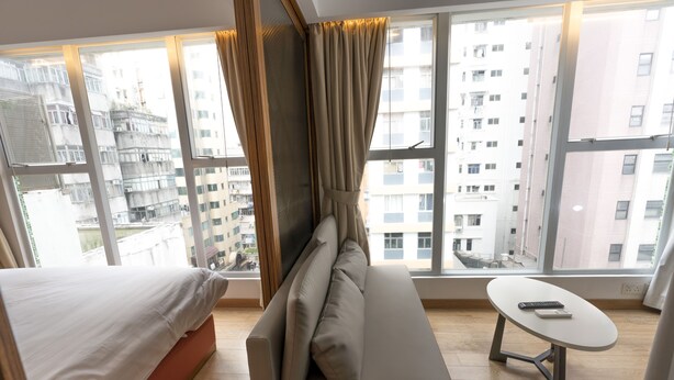 A modern hotel room with a bed, sofa, and a small table. - Homy Residence (Kowloon)
