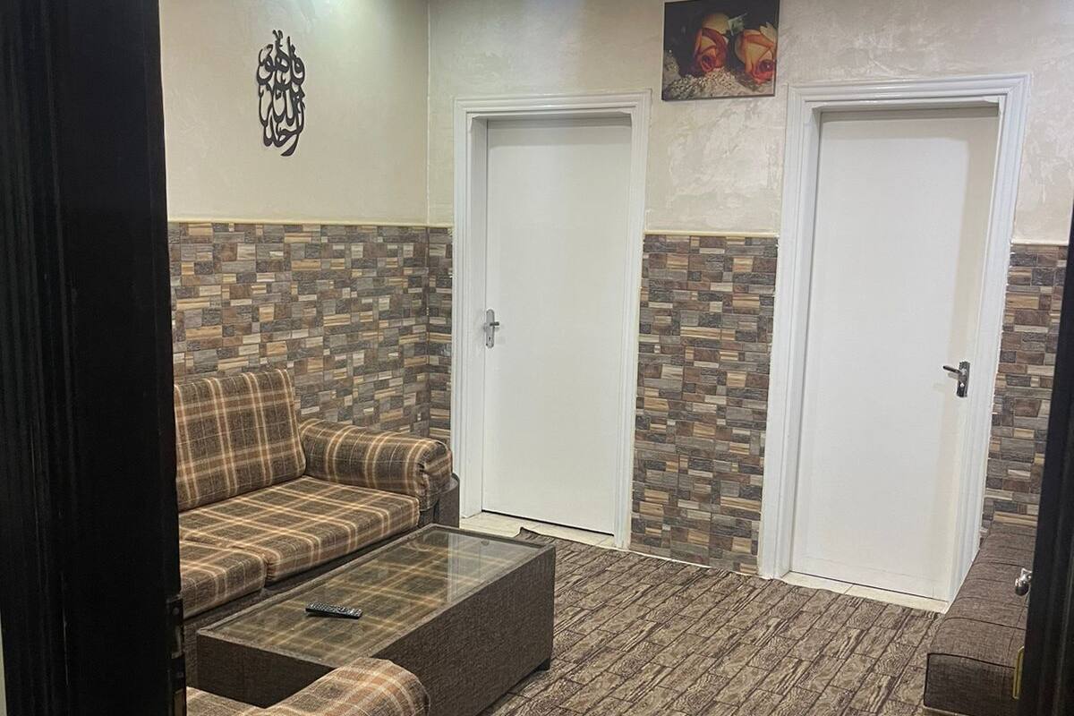 A room with a sofa, two doors, and a patterned floor.