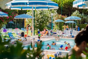A pool area with multiple lounge chairs and umbrellas. - Salinello Camping Village (Tortoreto)