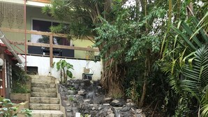 A garden with a pond, stone steps, and a small waterfall. - La Caz Océane (Saint-Leu)