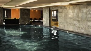 An indoor swimming pool with clear water, lounge chairs, and a modern design. - Sirius Beach Hotel & SPA (Varna)