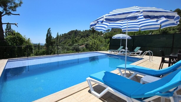 Una piscina al aire libre, sombrillas, tumbonas
