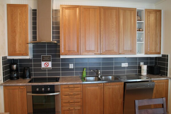 A kitchen with wooden cabinets, a stainless steel sink, and a dishwasher.