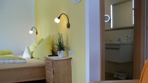 Une chambre à coucher avec un lit, une table de chevet, une lampe et une chaise.