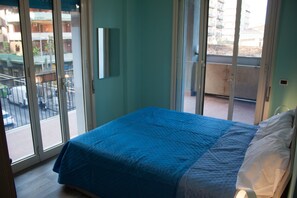 A bedroom with a bed, a window, and a view of the street outside. - Seaside & City (Catania)