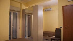 Ein Schlafzimmer mit Bett, Stuhl, Kleiderschrank und Spiegel.