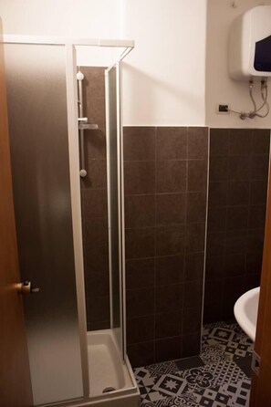 A bathroom with a shower, a toilet, and a sink. - Seaside & City (Catania)
