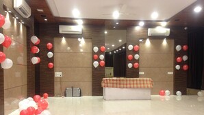 Una habitación amplia con una larga mesa cubierta por un mantel a cuadros, rodeada de globos.