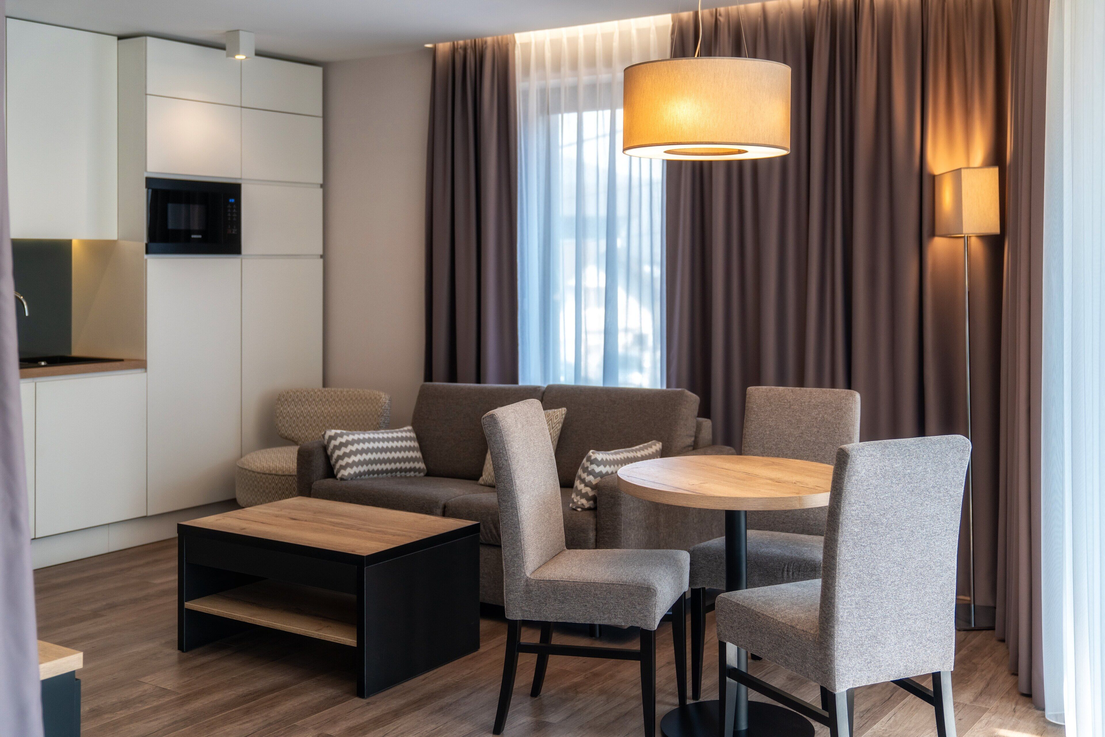 Uma sala de estar moderna com sofá, cadeiras, mesa de centro e mesa de jantar.