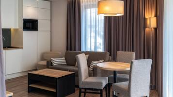 Uma sala de estar moderna com sofá, cadeiras, mesa de centro e mesa de jantar.