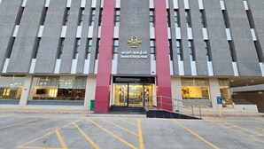 The exterior of the Sood Al Najje Hotel with a modern architectural design, featuring a prominent entrance with glass doors and a staircase leading up to the entrance. - Snood Al Narjis Hotel (Riyadh)