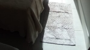 A bedroom with two beds, a large window, and a view of greenery outside. - Apartamento Praia do Santinho (Florianópolis)