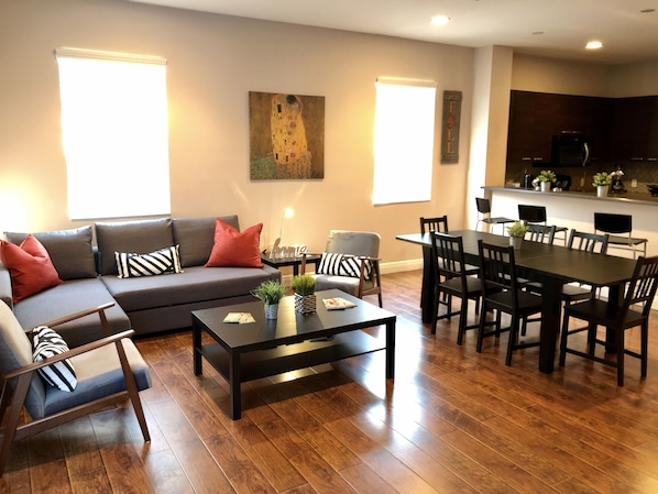 Una sala de estar moderna con sofá, mesa de centro y mesa de comedor.