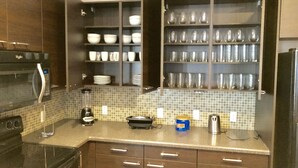 A kitchen with dark wooden cabinets, a microwave, a coffee maker, and a toaster.