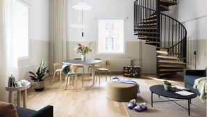 A modern living room with a spiral staircase, a round dining table, and a cozy seating area. - Bob W Helsinki City Centre (Helsinki)