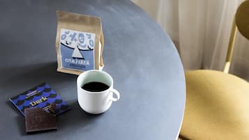 A table with a coffee cup, a chocolate bar, and a coffee bag.