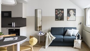 A modern living room with a sofa, a dining table with chairs, a kitchen area, and artwork on the walls. - Bob W Helsinki City Centre (Helsinki)
