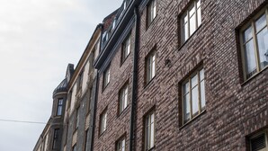 A multi-story building with a brick facade and multiple windows.