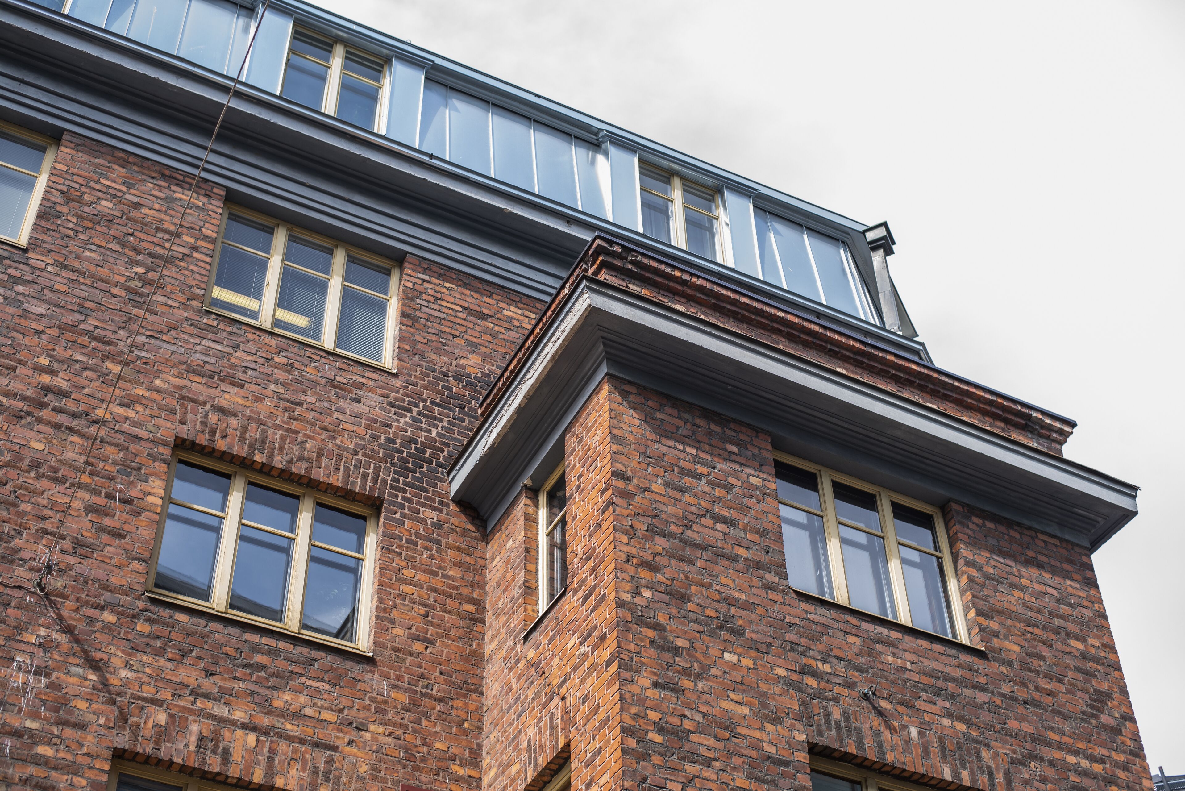 A multi-story brick building with large windows and a flat roof.
