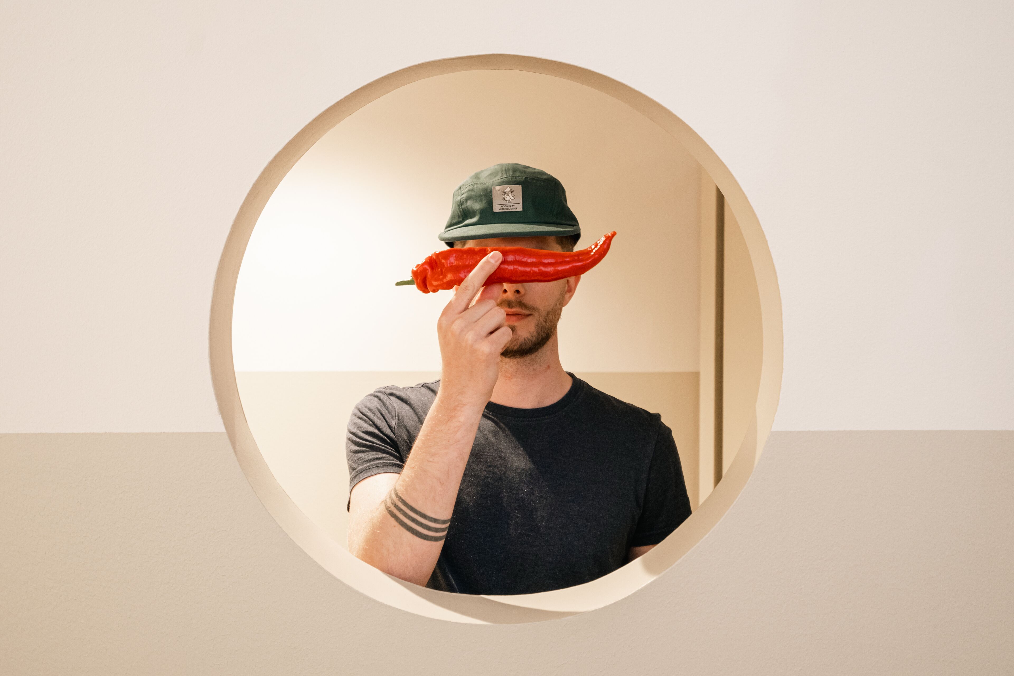 A person in a room with a circular mirror reflecting part of the room.