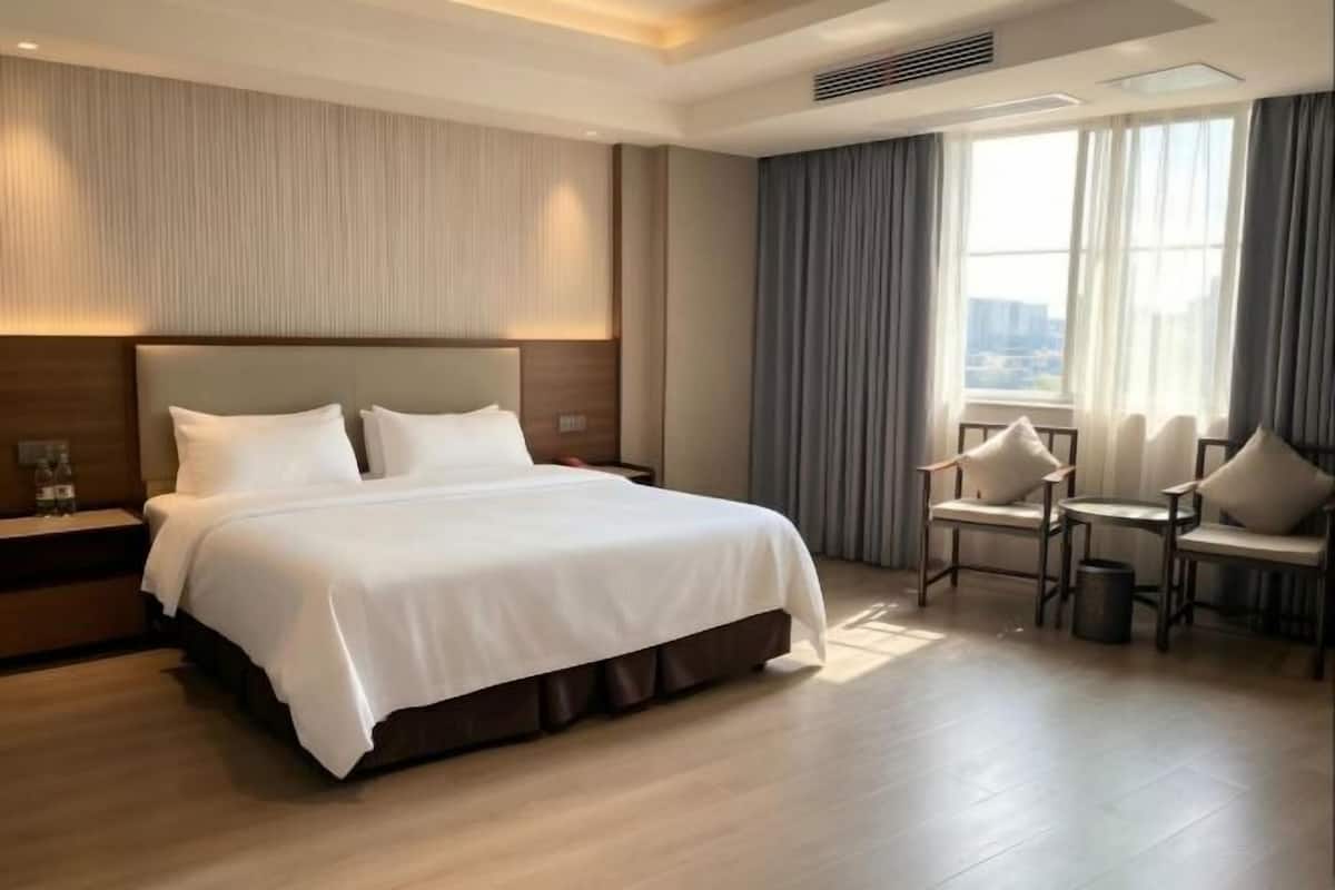 Een hotelkamer met een groot bed, een bureau en een stoel.