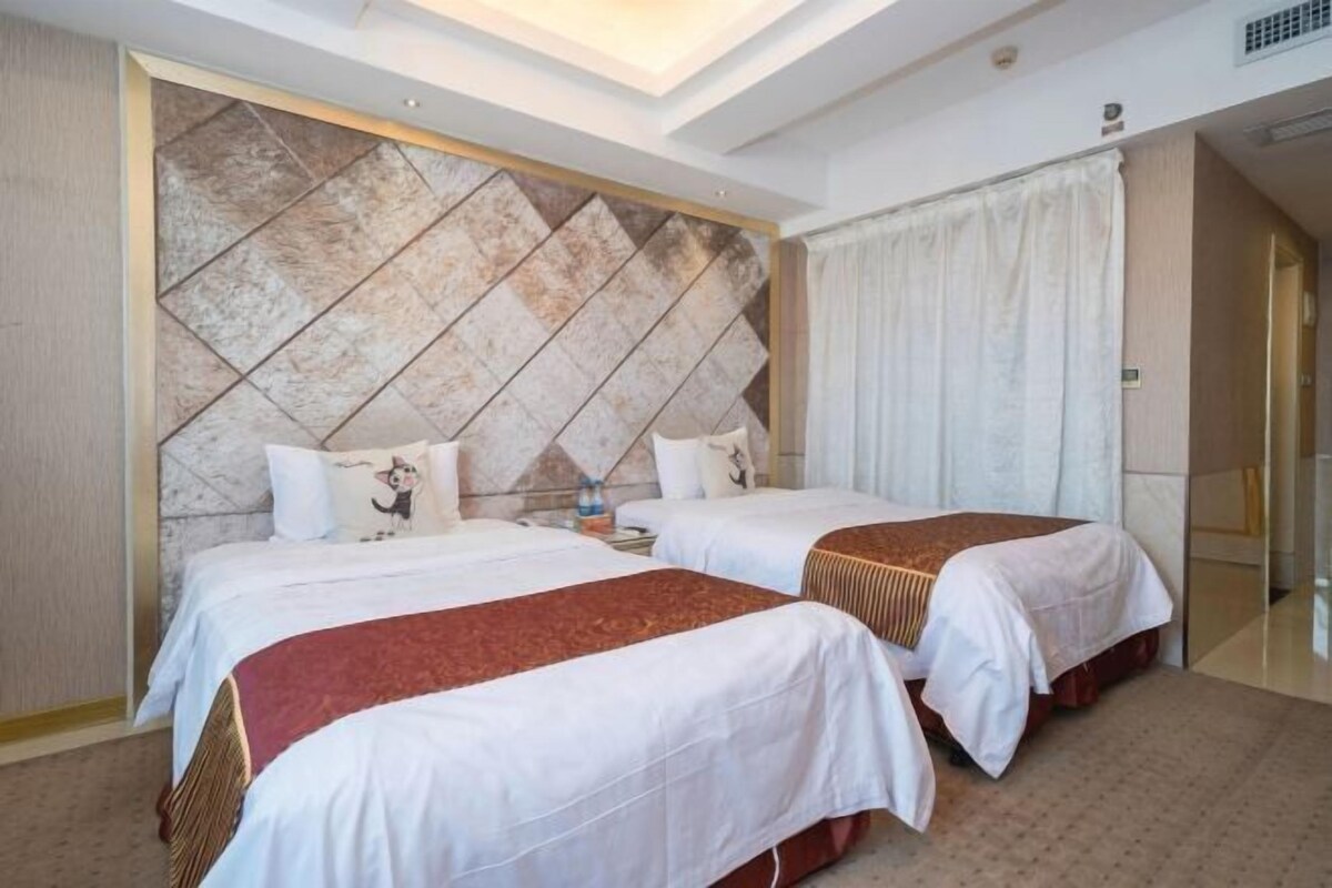 A hotel room with two beds, a large decorative wall, and a modern ceiling design.