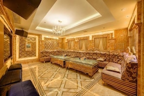 A luxurious room with a large sofa set, a pool table, and a chandelier. - Wanjia Dongfang Hotel (Shishi)