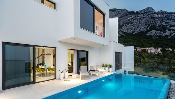 A modern two-story house with a swimming pool, outdoor seating, and a mountain view. - Villa Zvizdan (Makarska)