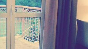 A room with a large window, a view of a balcony with a railing, and a curtain partially drawn. - 60Quattro Bedrooms (Lamezia Terme)