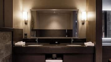 A modern bathroom with a large mirror, two sinks, and a towel rack.