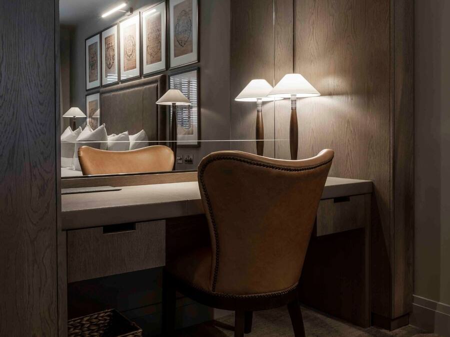 A modern bathroom with a vanity, a mirror, and two wall-mounted lamps.