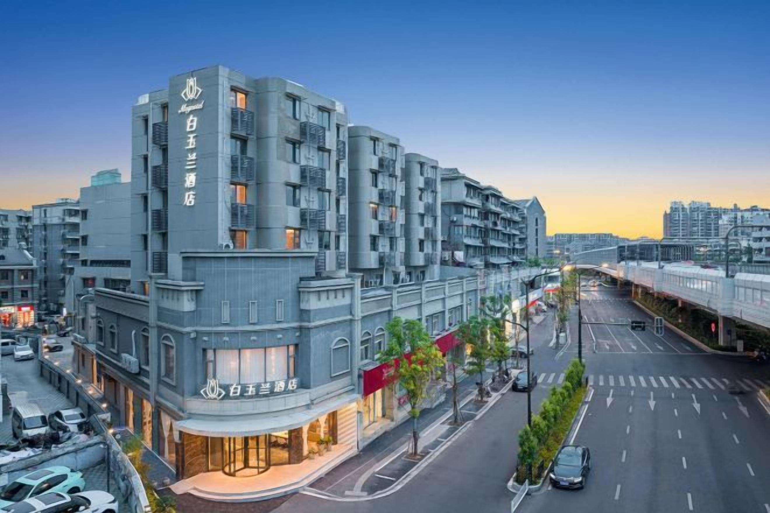 A multi-story hotel with a modern design, featuring a prominent entrance and a visible street view.