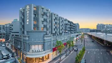 A multi-story hotel with a modern design, featuring a prominent entrance and a visible street view.