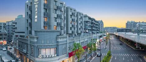 A multi-story hotel with a modern design, featuring a prominent entrance and a visible street view.