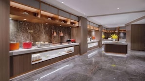 Une cuisine moderne avec des plans de travail en marbre, des étagères en bois et des luminaires suspendus.