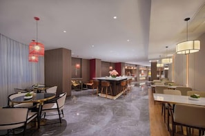 A modern hotel lobby with a bar area, dining tables, and a marble floor. - Magnotel Hotel (Nanjing Hongshan Zoo Maigaoqiao Subway Station) (Nanjing)
