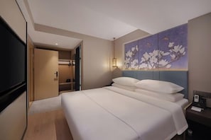A hotel room with a large bed, a painting on the wall, a TV, and a desk with a lamp. - Magnotel Hotel (Nanjing Hongshan Zoo Maigaoqiao Subway Station) (Nanjing)