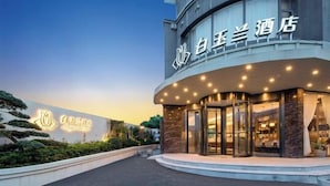 Un hôtel à l’architecture moderne, avec une façade incurvée et une enseigne lumineuse.