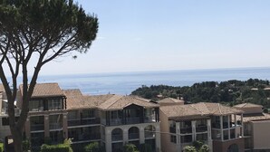 Eine Küstenwohngegend mit mehrstöckigen Gebäuden, Balkonen und Blick auf das Meer.