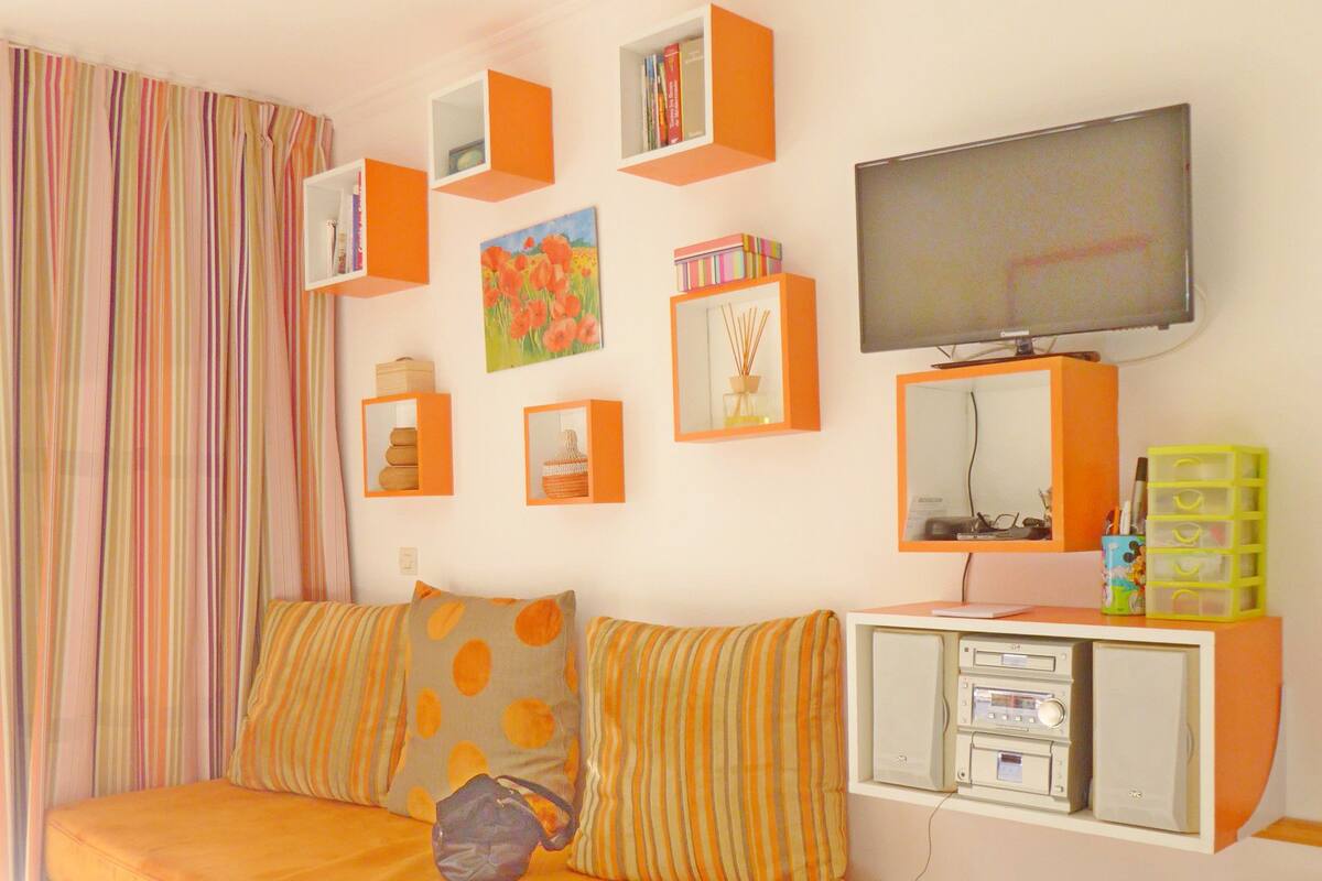 Une chambre moderne comprenant un lit, un bureau, une télévision et des meubles de rangement.