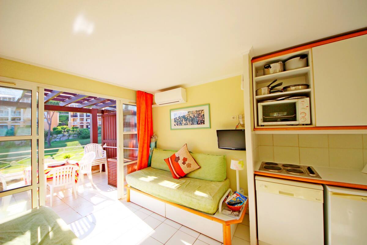 Un espace de vie compact comprenant un canapé, un coin repas et une kitchenette.
