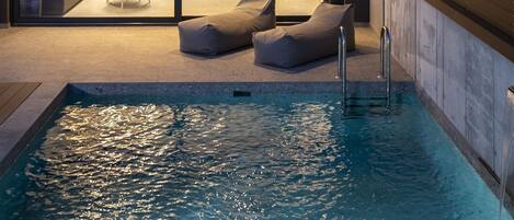 Alberca al aire libre, sombrillas en la alberca y camastros