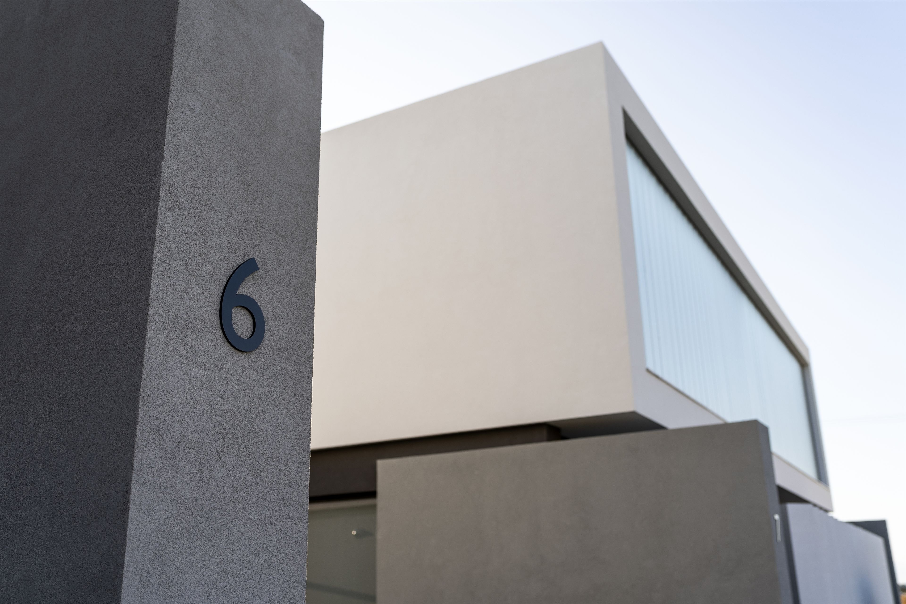 A modern building with a large number '6' on a grey wall.