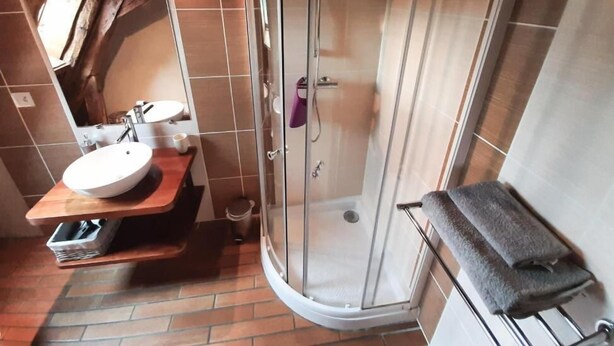 A bathroom with a glass-enclosed shower, a sink with a wooden countertop, and a towel rack. - Chambres D'Hôtes La Ferme de la Croix (Saint-Avit-Senieur)